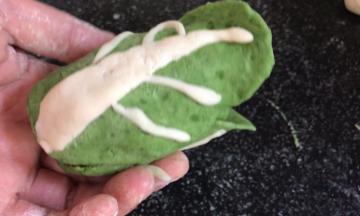 再把三片有白菜邦的叶子，一片叠加一片的包在嫩叶外面