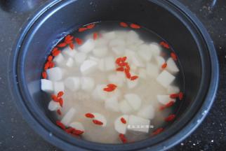 把山药和枸杞放入锅里，用勺子拌匀，这样煮好的米饭就不会所有的山药都浮在表面了。