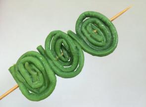 沸水中放精盐，把豇豆焯烫至翠绿变软 ，取出过冷水，卷起，穿成串