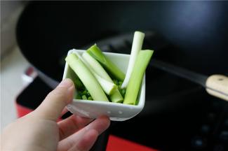 油微热加入之后，再将青蒜段下锅，煎至出味出香，青蒜段微微有点发黑也不怕。