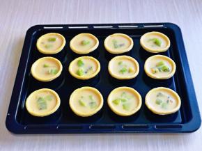 再把做好的蛋挞液倒入挞皮中，八分满即可。(小心不要将蛋挞液低落在烤盘上哈)