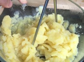 把蒸熟的土豆放入，大点的容器中，压成泥状