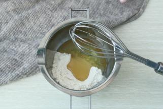 将脆皮糊部分的面粉和玉米油倒入干净碗里，用手动打蛋器搅打混合均匀，细腻无干粉即可。