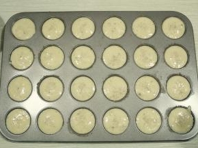 提起裱花袋，拧紧袋口。将裱花袋剪小口，挤入刷好脆皮糊的模具中。9分满，撒入白芝麻。如果没有白芝麻，黑芝麻也可以。