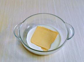 首先将淡奶油倒入玻璃器具中，芝士片去掉包装，加入奶油中。