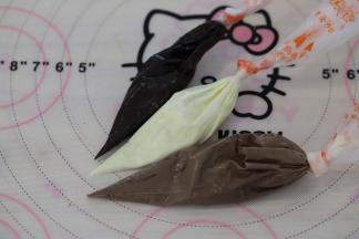 用白巧克力和棕色巧克力调出浅棕巧克力液，装入裱花袋内，再准备一份白色的巧克力液和深棕色的巧克力液。