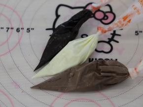 用白巧克力和棕色巧克力调出浅棕巧克力液，装入裱花袋内，再准备一份白色的巧克力液和深棕色的巧克力液。
