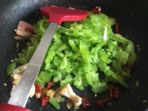炒干水分后，倒入辣椒、苦瓜继续翻炒3分钟左右；