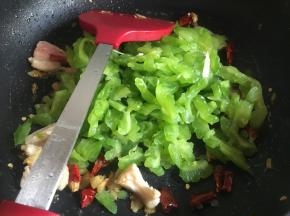 炒干水分后，倒入辣椒、苦瓜继续翻炒3分钟左右；