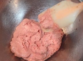 直到肉泥达到非常细腻，粘性很大，筷子挑起来还能拉丝的粉色状态