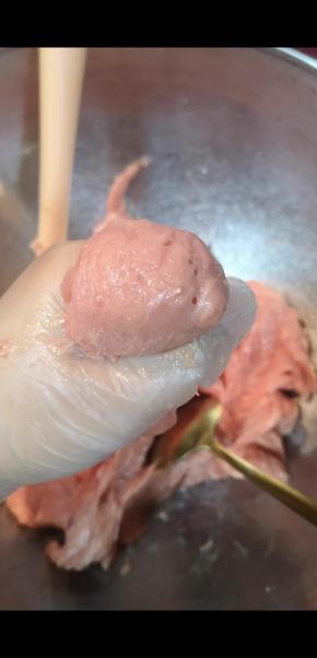 用手抓取一团肉泥，用虎口的力量挤出一个圆球，勺子上蘸些水，将挤出的圆球取下，放入锅中，几秒后肉丸会自动脱落