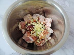 将之前切好的葱白、姜末、蒜末全部倒入排骨中。