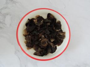将泡发的木耳清洗干净，撕成小朵，去掉根部，然后均匀的铺在碗底。