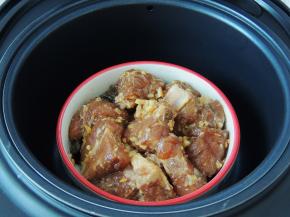 巧釜脱糖电饭煲的三角釜内放入清水到最低水位线，然后将码放好的排骨放入电饭煲的甄子里面，将甄子放入三角釜中。