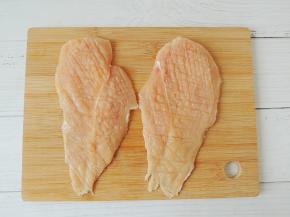 将鸡胸肉清洗干净，去掉表面的肥油和筋膜，然后横向对半剖成两片，再用刀背轻轻拍松，目的是为了让鸡胸肉更加松软，也更容易入味。