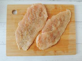 在处理好的鸡胸肉两面都撒一些盐和现磨黑胡椒粉，抹匀。