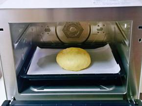 放在垫有油纸的烤盘中，入蒸烤箱进行发酵，发酵至原来的2倍大即可。(室温发酵也可以，但是一定要保持面团的湿度)