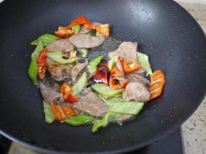 把猪肝倒进锅里，加入生抽和蚝油翻炒均匀。