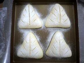 收口向下放在烤盘上发酵至1.5倍大，然后撒上一点面粉，用刀片割出花纹。