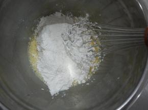 把过筛的低筋面粉倒入蛋黄糊中，混合均匀至无干粉状态。