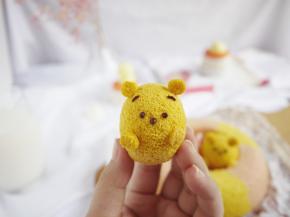 蛋糕烤好后取出冷却，剥去蛋壳，挤上眼睛、鼻子和眉毛。用白巧克力粘住耳朵和手。