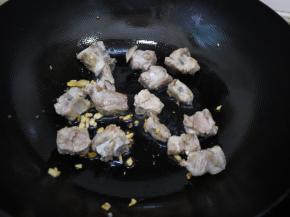 热锅凉油，把大蒜和姜放入锅中煸炒出香味。然后把排骨倒入锅中，翻炒至两面金黄。