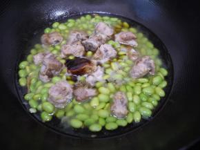 把毛豆放入锅中和排骨一起翻炒均匀，然后加入适量的水、生抽、蚝油、老抽，大火烧开后转小火焖煮10分钟。