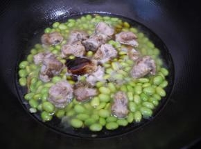 把毛豆放入锅中和排骨一起翻炒均匀，然后加入适量的水、生抽、蚝油、老抽，大火烧开后转小火焖煮10分钟。