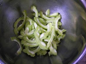 苦瓜清洗干净，然后切开，挖去里面的囊，再切成薄片。这样做是为了降低苦瓜的苦味。