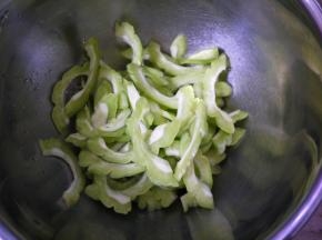 苦瓜清洗干净，然后切开，挖去里面的囊，再切成薄片。这样做是为了降低苦瓜的苦味。