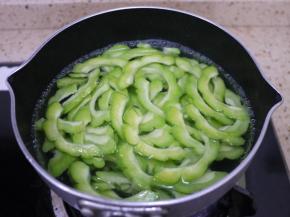 锅里烧一点开水，把苦瓜放进水里焯水1分钟，捞出后放冷水中降温，然后沥干备用。