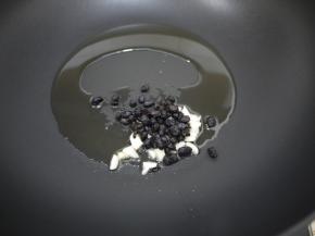 锅烧热后加入花生油，把切碎的大蒜和豆豉放进去煸炒出香味。