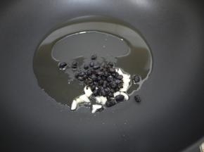 锅烧热后加入花生油，把切碎的大蒜和豆豉放进去煸炒出香味。