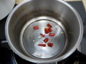 制作香辣油。把干辣椒切成小段，放在锅中小火煸一下，锅中不用放油，干煸就可以，大概煸炒一分钟，注意不要把辣椒炒糊。