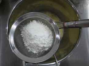 把80克的低筋面粉和玉米淀粉过混合后过筛，倒入蛋黄糊中，用打蛋器搅拌至无干粉、无颗粒的状态。