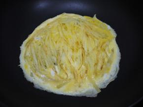 土豆饼煎至两面金黄之后，把鸡蛋从土豆饼的边缘倒入，继续中火煎至鸡蛋熟透。