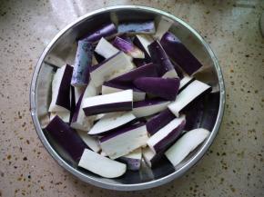 茄子清洗干净然后切成小段，把切好的茄子放在水里，然后加1点醋，把茄子泡一下。这样做是为了防止茄子变黑。