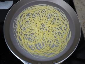 准备一个不粘平底锅，烧热后转小火。裱花袋剪一个小口，然后把面糊挤到不粘锅上，以画圆圈的方法，面糊最好不断开。