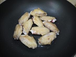 热锅凉油，把腌制好的鸡翅放进去锅里煎至两面金黄。鸡翅煎好之后取出放在碟子上备用。