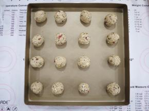 把面团平均分成20g每个，搓成圆球放在烤盘上。