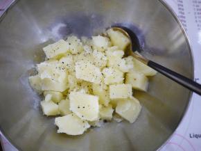 把蒸好的土豆和鸡蛋取出，土豆里加黑胡椒碎和盐趁热压成泥。