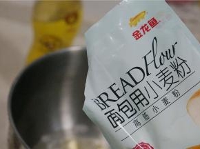 然后将金龙鱼面包用小麦粉配在里面，刚好500克的量。然后再加入酵母，厨师机选择二档模式，揉至15分钟的样子，再加入玉米油继续揉至面团光滑出膜。