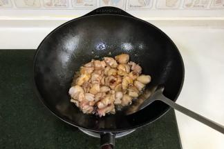 迅速倒入鸡块，转大火快速翻炒，加入2勺料酒。