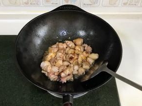 迅速倒入鸡块，转大火快速翻炒，加入2勺料酒。