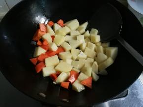 锅中余油放入胡萝卜土豆丁