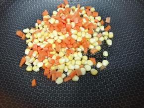 锅里加入适量的油，把玉米粒，胡萝卜丁放入锅中翻炒片刻