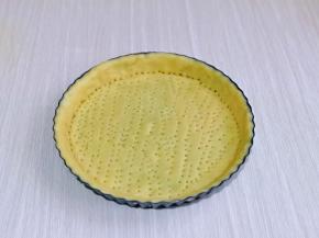 取出冷藏好的面团，擀圆饼，放入派皮中，将边缘多余的派皮去掉，再用叉子叉出不规则的洞洞。