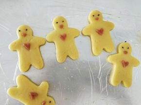 把爱心沾到宝宝饼干身上，放两颗芝麻做眼睛，然后另外再用点红色做嘴巴。