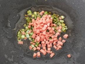 接着放入火腿肠丁小火煸炒一下。