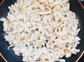 热锅凉油，放入腌制好的鸡丝，翻炒至鸡丝发白即可盛出备用。